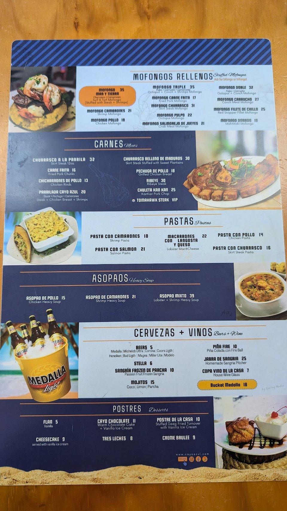 Printed menu pages beside a plated seafood dish